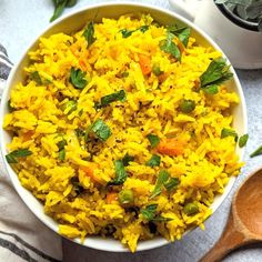 a white bowl filled with yellow rice and vegetables