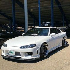 a white sports car parked in a parking lot