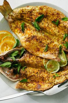 grilled fish with lemons and herbs on a plate