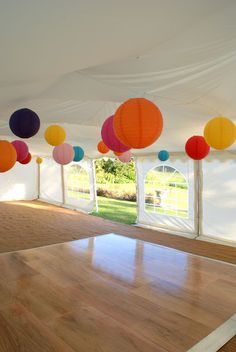 an empty room with paper lanterns hanging from the ceiling and wood flooring in front of it