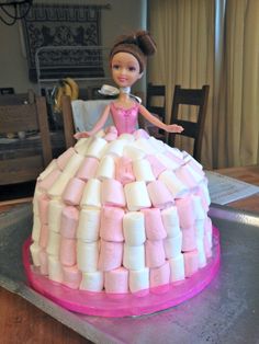 a cake made to look like a princess sitting on top of marshmallows