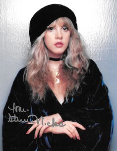 a woman with long blonde hair wearing a black hat