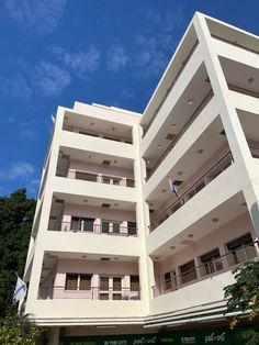 an apartment building with balconies and balconies on the second floor, against a blue sky