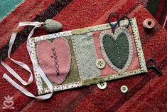 a piece of fabric with hearts on it and some sewing tools laying next to it