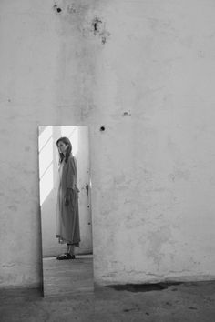 a woman standing in front of a mirror with the reflection of her face on it