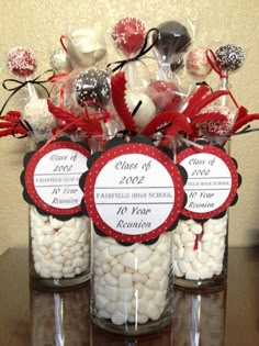 three glass jars filled with white and red candies