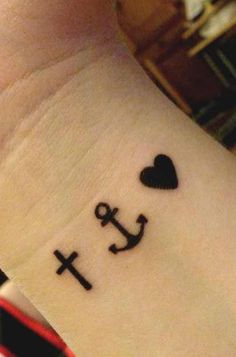 an anchor and heart tattoo on the wrist