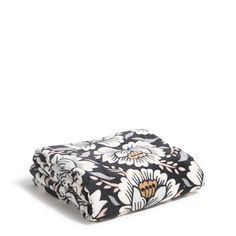 the black and white flowered blanket is folded on top of it's own