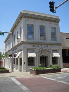 a street corner with a white building on the corner and a traffic light above it