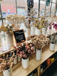 many flowers are in white vases on a table