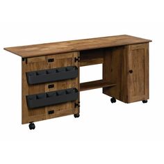 a wooden desk with three drawers and two black bins on it's sides