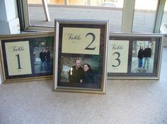 three framed photos are sitting on the floor next to each other, one is holding a couple's wedding date