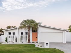 a white house with palm trees in the front yard