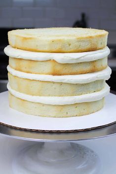 a stack of white cake sitting on top of a metal pan covered in frosting