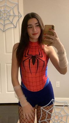 a woman taking a selfie in her spider - man costume while holding a cell phone