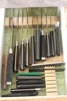 an open drawer with knives and other tools in it