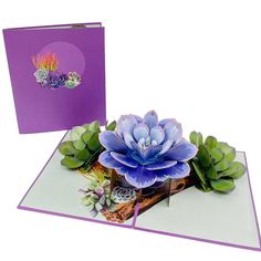 a purple card with succulents and flowers on it, next to an envelope