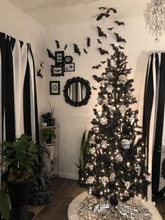 a black and white christmas tree in a living room with bats hanging on the wall