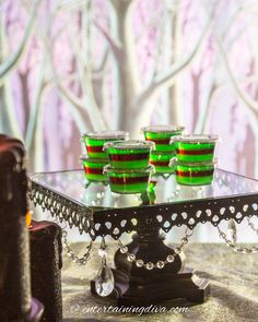 three green cups are sitting on a glass table