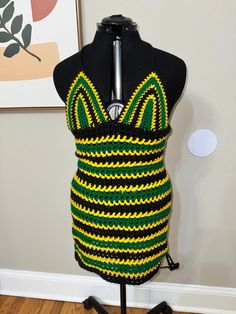 a mannequin with a green, yellow and black crochet top on it