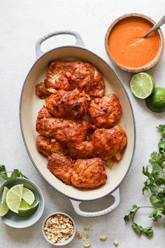 chicken wings in a pan with sauce and garnishes