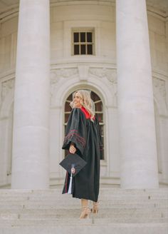 a woman in graduation gown standing on steps