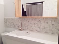 a white bathroom sink sitting under a mirror