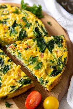 an omelet with spinach and tomatoes is cut into slices on a cutting board