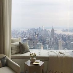 a living room filled with furniture and a view of the empire building in new york city