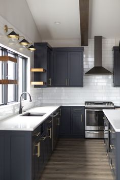 a kitchen with dark blue cabinets and white counter tops