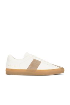 Find COMMON PROJECTS Tennis Trainer In White on Editorialist. Common Projects Tennis Trainer in White Leather upper and rubber sole. Made in Italy. Lace-up front. Suede paneling. Leather lining. COMF-MZ387. 2438-4102. About the designer: In 2004, armed with a desire to create the perfect sneaker, designers Flavio Girolami and Peter Poopat introduced a line of minimalist shoes to sneaker freaks around the world. Since the debut of their first collection, which featured only black, white, and gray sneakers, the line has grown to encompass more than your average laced-up low top. Today, Common Projects offers a range of colors, non-sneaker styles, and materials that are luxurious in look and feel. Custom Beige Leather Sneakers With Gum Sole, Beige Leather Custom Sneakers With Gum Sole, Custom Cream Leather Sneakers With Gum Sole, Cream Leather Custom Sneakers With Gum Sole, Beige Leather Sneakers With Rubber Heel Cap, Modern White Custom Sneakers With Rubber Heel Cap, Cream Leather Sneakers With Contrasting Heel Counter, Cream Leather Sneakers With Contrasting Heel, Tennis Trainer