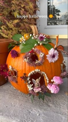 two pumpkins decorated with flowers and leaves on a porch