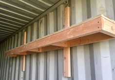 two wooden shelves are attached to the side of a shipping container