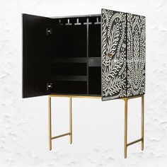 a black and white cabinet sitting on top of a wooden stand