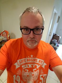 a man wearing an orange shirt and glasses