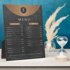 a menu board sitting on top of a table next to an hour glass and sand clock