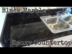 a black marble kitchen counter top with two sinks