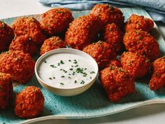 a blue plate topped with meatballs next to a small bowl of ranch dressing on top of it