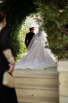 the bride and groom are walking down the stairs