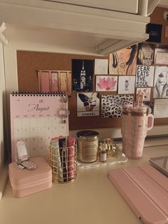 there is a calendar, cups and other items on the desk