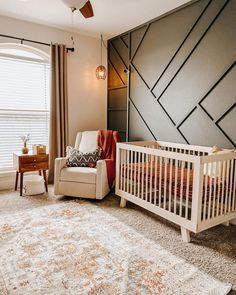 a baby's room with a crib, chair and rug in the corner