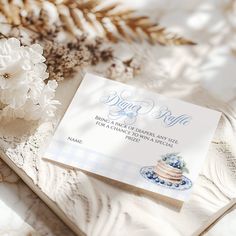 a wedding card on top of a table next to flowers