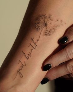 a woman's hand with a dandelion tattoo on her left wrist that says, thank you