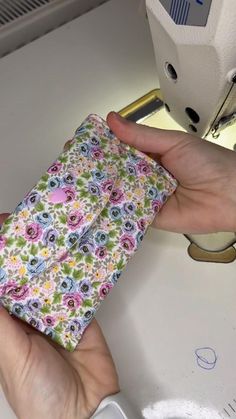 a person is using a sewing machine to sew flowers on a fabric piece in their hand