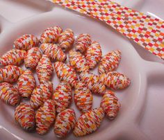 there are many small donuts on the plate with a red and yellow striped ribbon