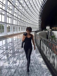 a woman walking down a walkway in an airport