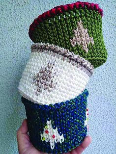 there is a hand holding a knitted cup cozy