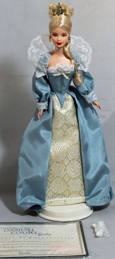 the doll is wearing a blue and white dress with a tiara on her head