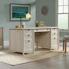 a desk with two drawers and a clock on the wall above it in a living room