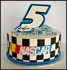 a birthday cake that has the number five on it and is decorated with racing cars